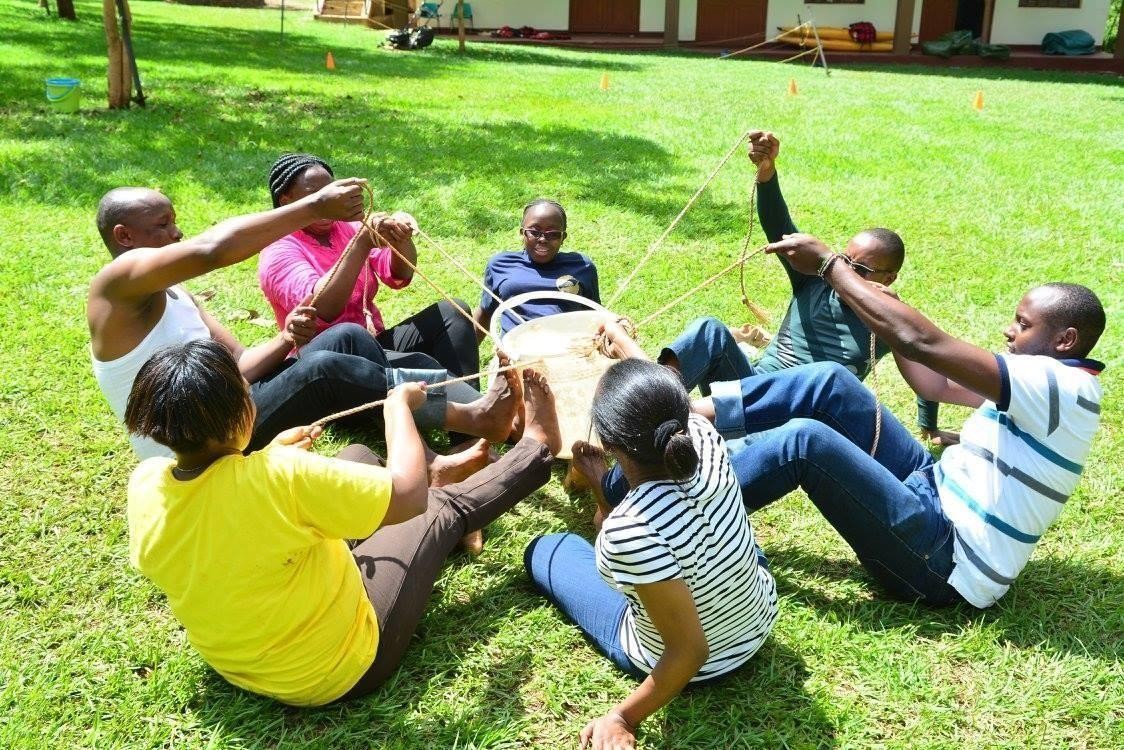 Colleagues doing a team-building exercise on a lawn