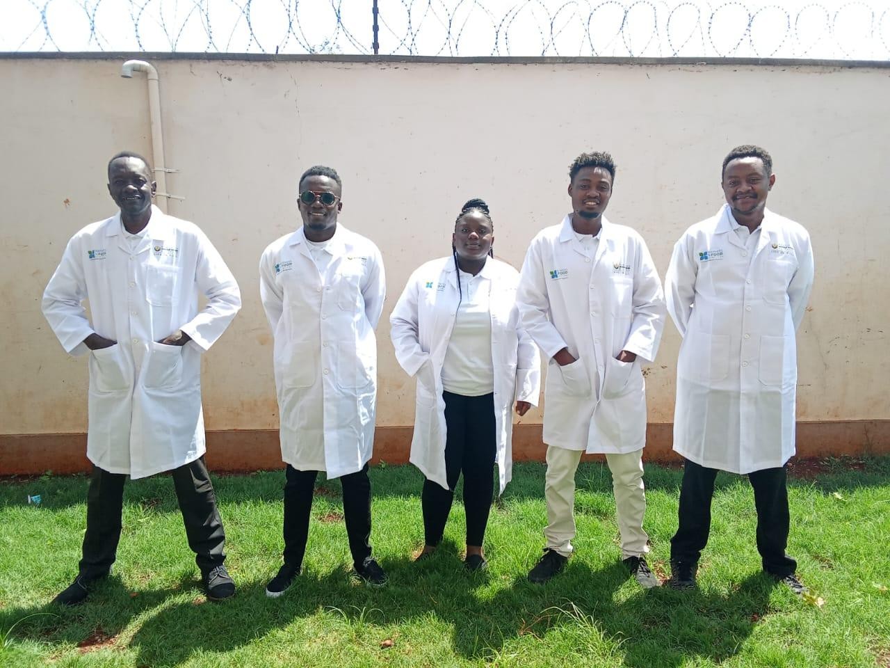 Posho millers in white coats at an FWGA training session